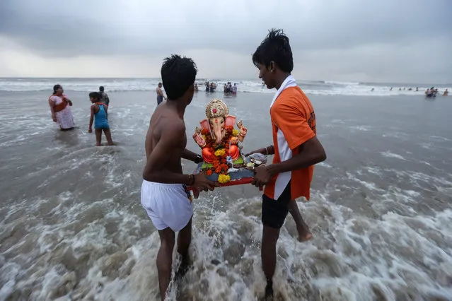 Young Indian devotees carry a representation of the elephant-headed Hindu god Lord Ganesha into the Arabian Sea during celebrations of the god's birth in Mumbai, India, 21 September 2015. During the Ganpati festival, celebrated as the birthday of Lord Ganesha, devotees worhsip representations of the Hindu deity at hundreds of pandals, makeshift tents, before they are taken into the waters. (Photo by Divyakant Solanki/EPA)