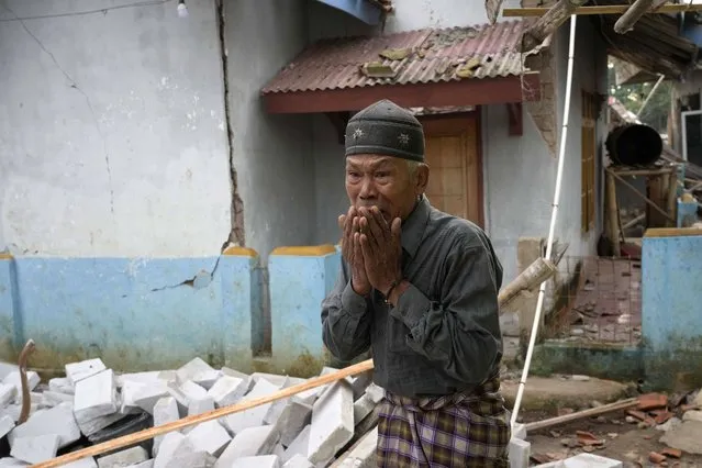 A man reacts as he inspects the damage caused by Monday's earthquake in Cianjur, West Java, Indonesia Tuesday, November 22, 2022. The earthquake has toppled buildings on Indonesia's densely populated main island, killing a number of people and injuring hundreds. (Photo by Tatan Syuflana/AP Photo)