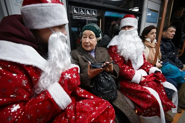 Employees of Moscow Metro dressed as Father Frosts take part in a Christmas and New Year flash mob for passengers in the Moscow underground on December 30, 2022. (Photo by Natalia Kolesnikova/AFP Photo)