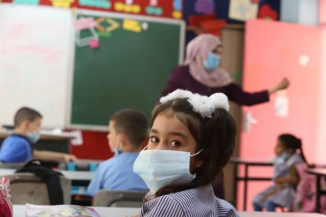 Palestinian students wearing protective face masks start face-to-face learning at Al-Birah Primary school as schools which have been closed due to the novel coronavirus (Covid-19) pandemic since March, resume for first, second, third and fourth grade students under Covid-19 measures in Ramallah, West Bank on September 06, 2020. (Photo by Issam Rimawi/Anadolu Agency via Getty Images)