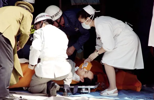 This file photo taken on March 20, 1995 shows a commuter being treated by an emergency medical team at a make- shift shelter before being transported to hospital after being exposed to sarin gas fumes in the Tokyo subway system during an Aum sect attack Shoko Asahara, the leader of the Aum Shinrikyo cult that carried out a deadly sarin attack on Tokyo' s subway in 1995, was executed on Friday, local media reported. (Photo by Junji Kurokawa/AFP Photo)
