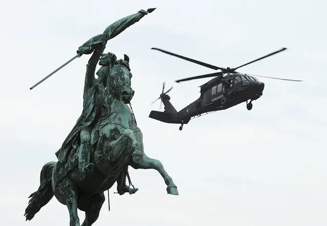 An Austrian Army Sikorsky S-70 "Black Hawk" helicopter hovers behind a statue of Archduke Charles as it lands in the centre of Vienna, Austria, October 19, 2015. The army is preparing for a presentation of its capabilites on Austria's National Day on October 26. (Photo by Heinz-Peter Bader/Reuters)