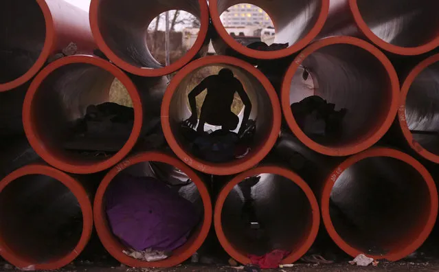 A Filipino man prepares his sleeping area inside a huge water pipe in suburban Pasay, south of Manila, Philippines Tuesday, October 20, 2015. Several homeless people have made the pipes as their temporary shelter. (Photo by Aaron Favila/AP Photo)