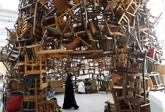 A visitor walks within an installation titled “Chairs”, made of wooden chairs by Japanese artist Tadashi Kawamata, during Abu Dhabi Art at Saadiyat island, off the coast of Abu Dhabi, November 7, 2012. (Photo by Jumana El-Heloueh/Reuters)
