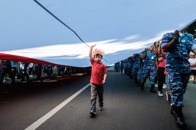A 100-metre-long flag in Indonesia's national colours is paraded through the streets in Bogor, West Java, on August 10, 2025, a week ahead of the country's 80th Independence Day celebrations. (Photo by Aditya Aji/AFP Photo)