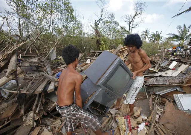 Typhoon victims recover a television set from the ruins of a house destroyed during the onslaught of Typhoon Hagupit in San Julian, eastern Samar in central Philippines December 9, 2014. Philippine emergency workers were struggling on Tuesday to reach coastal villages on an island hardest hit by a typhoon where thousands of homes have been wrecked by powerful winds and a storm surge rising three to four metres (10 to 13 feet). (Photo by Erik De Castro/Reuters)