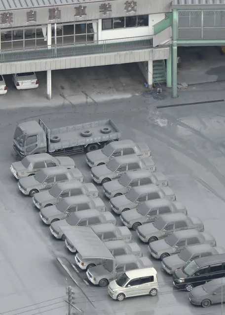 This aerial photo shows cars totally covered by gray ash parked on the compound of a driving school in Aso, Kumamoto Prefecture, southern Japan, Saturday morning, Oct. 8, 2016, following Mount Aso erupted earlier in the day. (Photo by Hiroko Harima/Kyodo News via AP Photo)