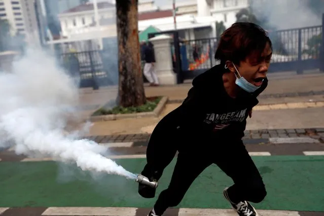 A demonstrator holds a tear gas canister to be thrown back to police during a clash between demonstrators and police following a protest against the new so-called omnibus law, in Jakarta, Indonesia, October 13, 2020. (Photo by Willy Kurniawan/Reuters)