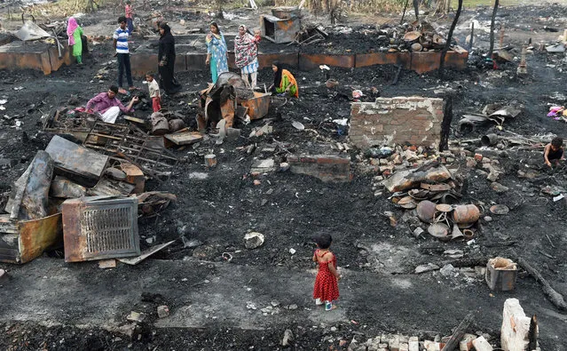 Rohingya refugees look for their belongings in New Delhi on April 16, 2018, following a fire that broke out at their camp early April 15 that left around 200 people homeless No casualties were reported after the fire ripped through the camp early in the morning April 15. The refugees living in New Delhi have fled persecution in Myanmar, with their numbers increasing following a brutal crackdown starting in September 2017 that saw hundreds of thousands pouring into neighbouring Bangladesh. (Photo by Money Sharma/AFP Photo)