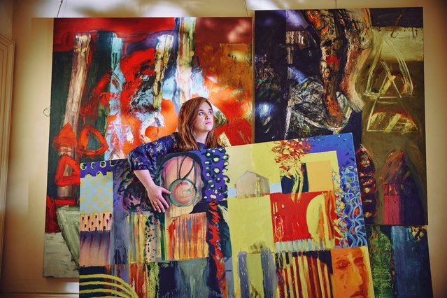 Scarlett Stewart poses on September 30, 2025 with paintings by Geoff Morten in The Sensation of Image exhibition at 108 Fine Art in Harrogate, UK, where his work is shown alongside ceramics by his wife, Jenny Morten. (Photo by James Glossop/The Times)