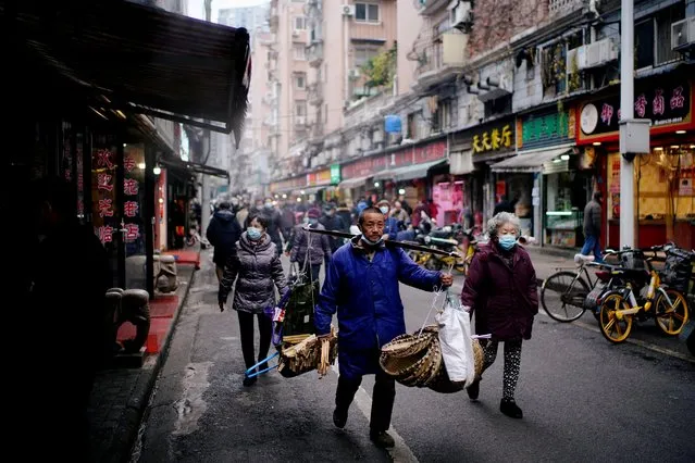 People wearing protective masks walk at a street market almost a year after the start of the coronavirus disease (COVID-19) outbreak, in Wuhan, Hubei province, China on December 7, 2020. (Photo by Aly Song/Reuters)