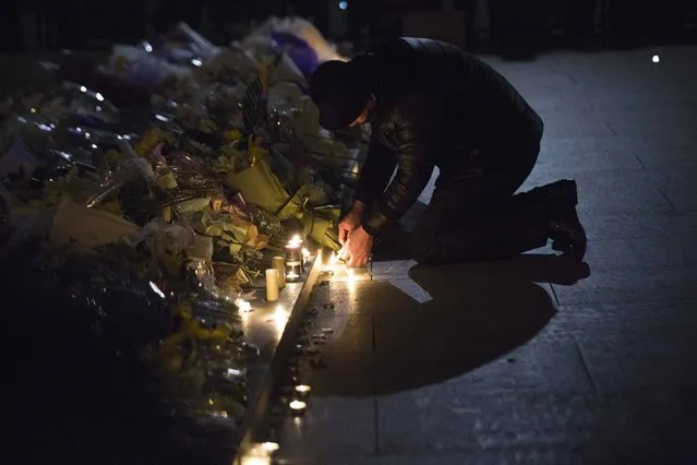 A man lights candles during a memorial ceremony for people who were killed in a stampede incident during a New Year's celebration on the Bund, in Shanghai January 1, 2015. (Photo by Aly Song/Reuters)