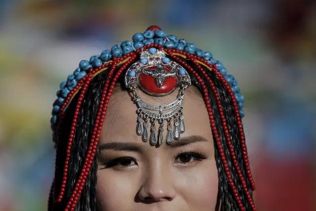 Jing Li wears a Tibetan traditional costume as she gets ready for her wedding photo to be taken at the Nianqing Tanggula mountain pass in the Tibet Autonomous Region, China November 18, 2015. Jing, 22, and her husband Ke Xu, 23, both from Shiyan in northwestern Hubei province live in Tibet for three year. The couple married last month. (Photo by Damir Sagolj/Reuters)