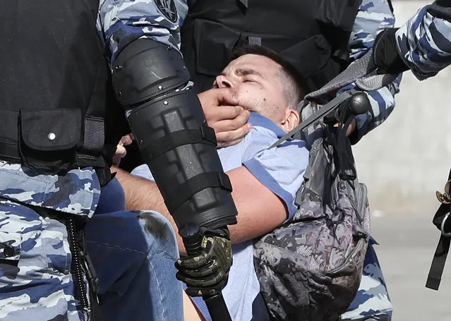 Russian police detain a protester at a demonstration against President Vladimir Putin in Pushkin Square in Moscow, Russia, Saturday, May 5, 2018. Thousands of demonstrators denouncing Putin's upcoming inauguration into a fourth term gathered Saturday in the capital's Pushkin Square. (Photo by Pavel Golovkin/AP Photo)