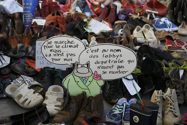Pairs of shoes are symbolically placed on a sidewalk near the Place de la Republique, due to the cancellation of a planned march following shootings in the French capital, ahead of the World Climate Change Conference 2015 (COP21), in Paris, France, November 28, 2015. Messages reads, "I walk for the climate, but it won't be for me" (L) and "Its in the name of oil lobbyists who don't dare show themselves". (Photo by Eric Gaillard/Reuters)