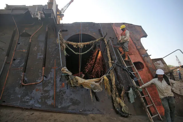 Workers dismantle a decommissioned ship at the Alang shipyard in Gujarat, India, May 28, 2018. (Photo by Amit Dave/Reuters)