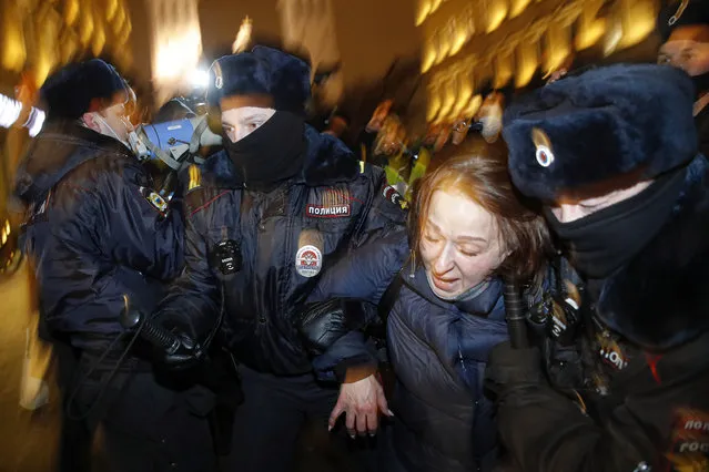 Police officers detain a Navalny supporter during a protest in St. Petersburg, Russia, Tuesday, February 2, 2021. A Moscow court has ordered Russian opposition leader Alexei Navalny to prison for more than 2 1/2 years on charges that he violated the terms of his probation while he was recuperating in Germany from nerve-agent poisoning. Navalny, who is the most prominent critic of President Vladimir Putin, had earlier denounced the proceedings as a vain attempt by the Kremlin to scare millions of Russians into submission. (Photo by Dmitri Lovetsky/AP Photo)