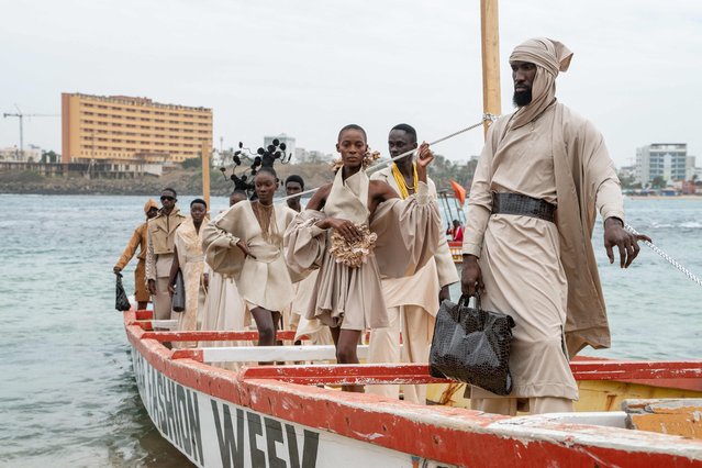 Models pose on a pirogue with the collection by designer “Service Almakhtoum” before the final show of Dakar Fashion Week, which takes place in Ngor Bay, Dakar, on December 6, 2025. (Photo by Nicolas Remene/AFP Photo)