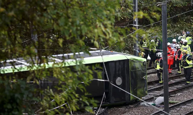 Members of the emergency services work next to a tram after it overturned injuring and trapping some passengers in Croydon, south London, Britain November 9, 2016. (Photo by Neil Hall/Reuters)