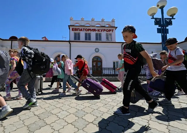 Children from from Russia's Belgorod Region, including those living in areas bordering Ukraine, arrive at a railway station on their way to a sanatorium in Yevpatoriya, Crimea on June 5, 2023. (Photo by Alexey Pavlishak/Reuters)