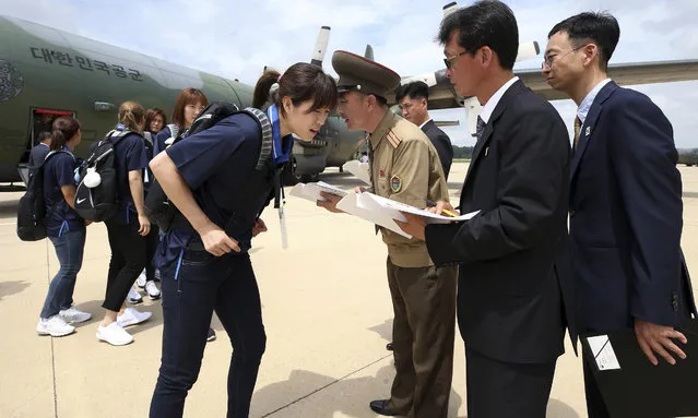 South Korean women's basketball team player Shim Sung-young, center left, has her identification checked by a North Korean official upon her arrival at the Pyongyang Airport in Pyongyang, North Korea, Tuesday, July 3, 2018. South Korean basketball teams and officials arrived on Tuesday to take part in the inter-Korean basketball match in Pyongyang. (Photo by Korea Pool via AP Photo)