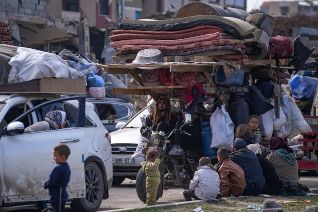Displaced Palestinians with their belongings gather near a roadblock on Salah al-Din Street, as they wait to return to their homes in the northern part of the Gaza Strip, Sunday, January 26, 2025, days after the ceasefire deal between Israel and Hamas came into effect. (Photo by Abdel Kareem Hana/AP Photo)