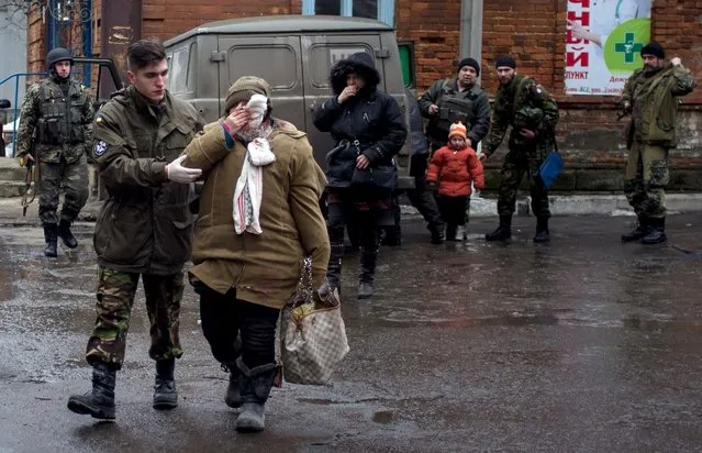 Ukrainian serviceman escort a wounded civilian woman in the eastern Ukrainian city of Artemivsk, in the Donetsk region on January 29, 2015. Twenty-four people, including 19 civilians, were killed in the past 24 hours in clashes between government forces and pro-Russian rebels in east Ukraine, officials said. (Photo by Laetitia Peron/AFP Photo)