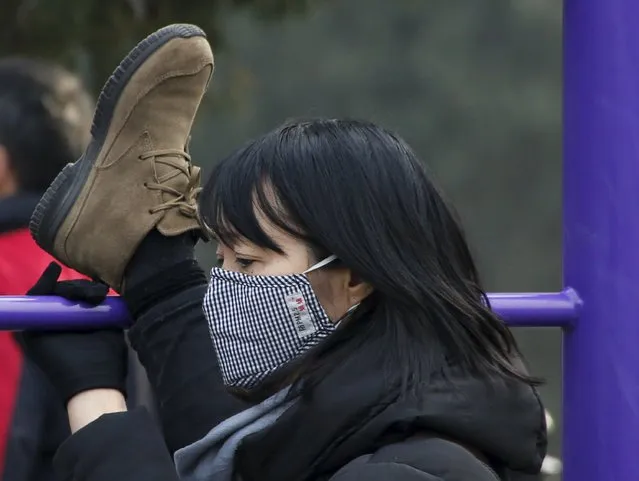A woman wearing a protective mask stretches her leg at a park as China's capital Beijing braces for four days of choking smog starting Saturday, in Beijing, China, December 19, 2015. (Photo by Kim Kyung-Hoon/Reuters)