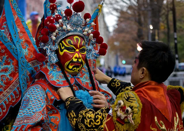 A dancer with the Chengdu (China) Panda float is assisted by a fellow dancer before the start of the Macy's Thanksgiving Day Parade in New York, Thursday, November 24, 2016. (Photo by Craig Ruttle/AP Photo)