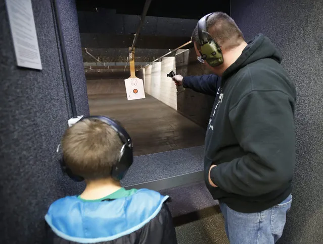 An unidentified man and his son target practice with a handgun at a gun range in Springville, Utah, USA, on 05 January 2016. (Photo by George Frey/EPA)