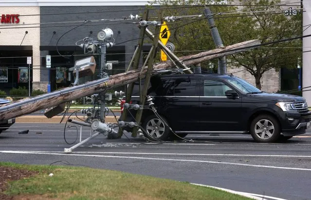 A downed power line that fell on an SUV can be seen the day after a powerful storm swept the region along Baltimore Blvd in Westminster, Maryland, U.S., August 8, 2023. (Photo by Leah Millis/Reuters)