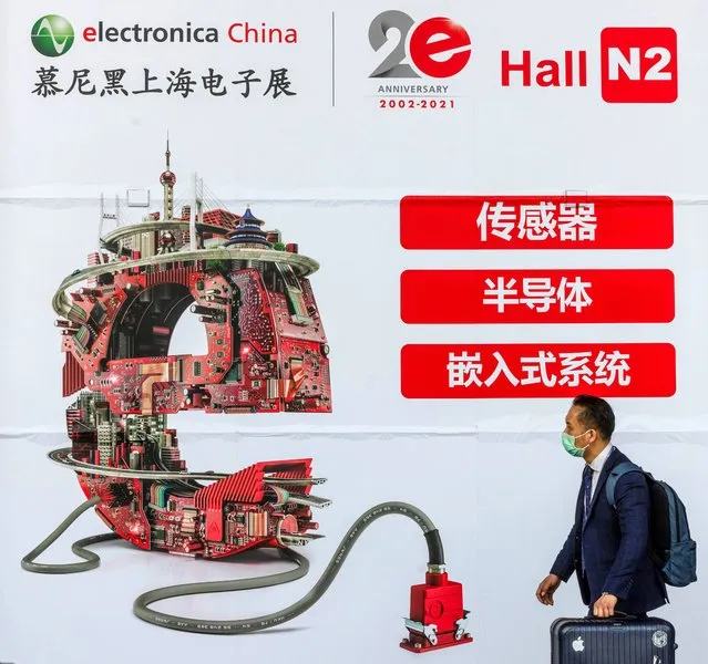 A visitor walks in front of the advertisement on the Electronica China Expo in Shanghai, China, 16 April 2021. Founded in 2002, electronica China is now one of the leading platforms for innovative electronics manufacturing and it's held from 14-16 of April 2021, with over 1,300 exhibitors worldwide. (Photo by Alex Plavevski/EPA/EFE)