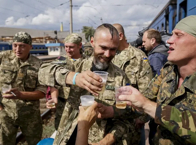Ukrainian servicemen drink champagne after returning from the frontline in the eastern regions, at a railway station in Kiev, Ukraine, September 9, 2015. (Photo by Gleb Garanich/Reuters)