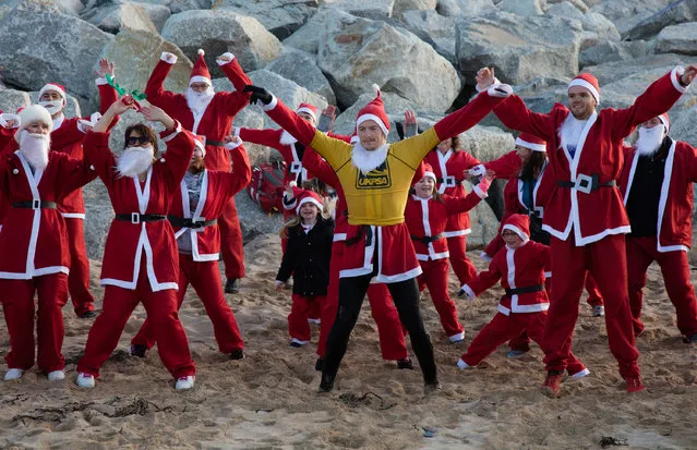 People dressed as Santa warm up prior to taking part in the beach fun run as part of the Santa Run and Surf 2016 at Fistral Beach in Newquay on December 4, 2016 in Cornwall, England. (Photo by Matt Cardy/Getty Images)