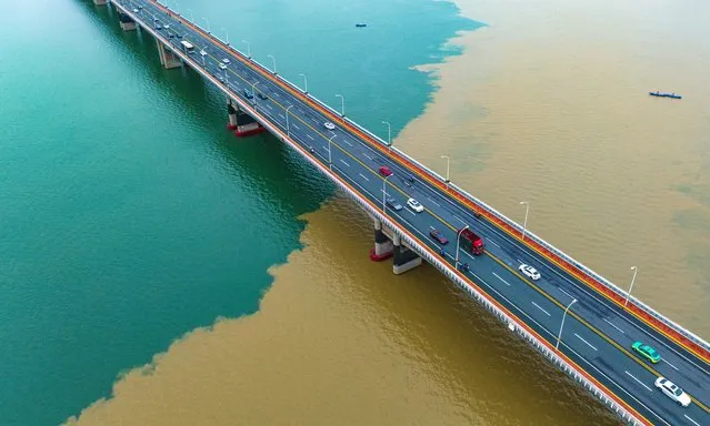 Aerial view of the green-yellow Han River after a heavy rainfall on August 27, 2023 in Xiangyang, Hubei Province of China. Heavy rainfall washes sand into the Han River, creating the colorful view. (Photo by Yang Dong/VCG via Getty Images)