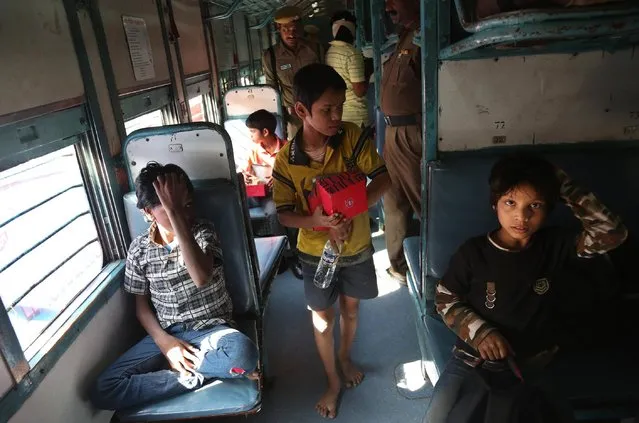 Indian rescued child laborers sit inside a train to be reunited with their parents in Bihar, one of India's poorest states, at a railway station in Hyderabad, India, Thursday, February 5, 2015. Police have rescued hundreds of children working in hazardous industries in a southern Indian city despite laws that ban child labor. (Photo by Mahesh Kumar A./AP Photo)