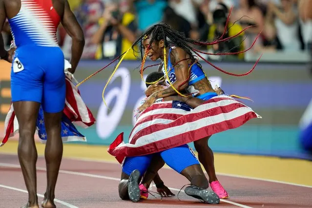 Sha'Carri Richardson, of the United States is greeted by members of the US men's team as she celebrates anchoring her team to gold in the Women's 4x100-meters relay final during the World Athletics Championships in Budapest, Hungary, Saturday, August 26, 2023. (Photo by Ashley Landis/AP Photo)