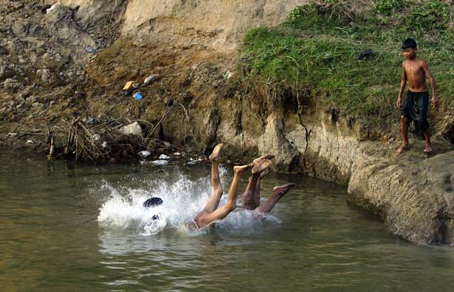 Children bathe in a creek on Thursday, December 15, 2016, in Naypyitaw, Myanmar. (Photo by Aung Shine Oo/AP Photo)