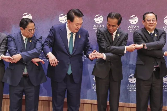 From left to right, Vietnam's Prime Minister Pham Minh Chinh, South Korean President Yoon Suk Yeol, Indonesian President Joko Widodo and Laos' Prime Minister Sonexay Siphandone hold hands for a family photo during the ASEAN-South Korea Summit in Jakarta, Indonesia, Wednesday, September 6, 2023. (Photo by Bagus Indahono/Pool Photo via AP Photo)