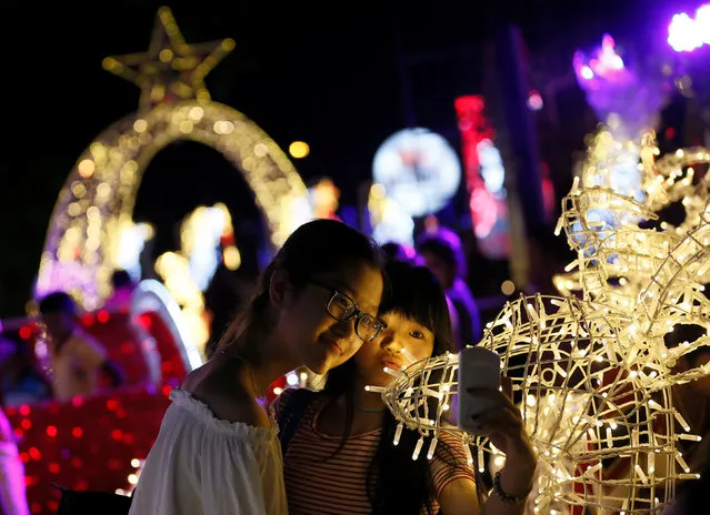 Girls take selfies with Christmas decorations in Colombo, Sri Lanka December 24, 2016. (Photo by Dinuka Liyanawatte/Reuters)