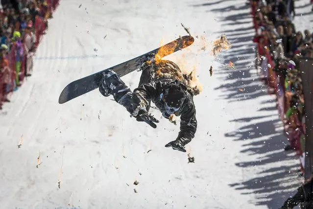 A snowboarder performs during the Red Bull Jump and Freeze competition at ski resort Shimbulak outside Almaty March 22, 2015. Participants wearing festive costumes perform tricks before getting into a pond with icy water. (Photo by Shamil Zhumatov/Reuters)