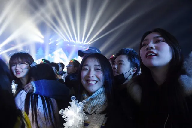Chinese women watch performances during New Year celebrations in Beijing on December 31, 2016. (Photo by Greg Baker/AFP Photo)