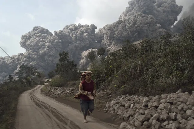 A villager runs as Mount Sinabung erupts at Sigarang-Garang village in Karo district, February 1, 2014. (Photo by S. Aditya/Reuters)