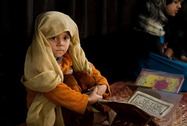 Sakina waits for a teacher to recite verses from the Quran during religion class at a local mosque in Islamabad, Pakistan, Thursday, December 19, 2013. Religious schools in Pakistan mostly set up in mosques are potential source of education for thousands of children. (Photo by B. K. Bangash/AP Photo)