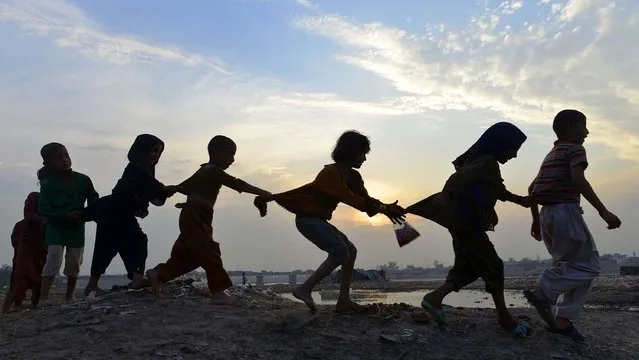 Pakistani children play near the Ravi river in Lahore on April 6, 2015. (Photo by Arif Ali/AFP Photo)