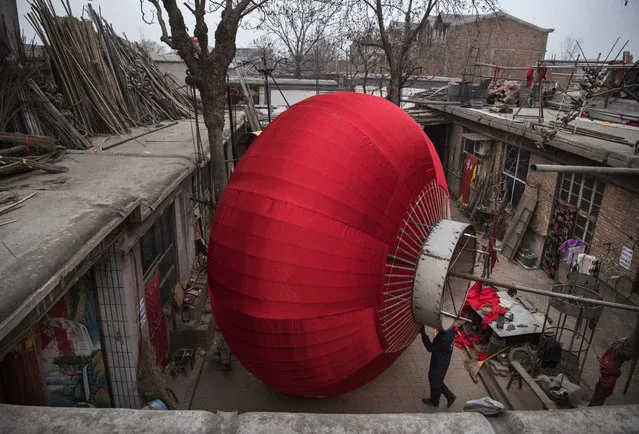 A Chinese worker makes a giant traditional red lantern outside at a local factory on January 24, 2019 in the village of Tuntou, in Hebei province, China. (Photo by Kevin Frayer/Getty Images)