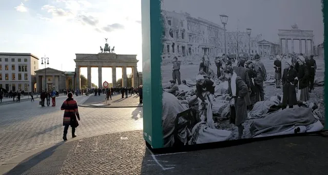 People walk next to historic picture taken in May 1945 which is part of an open air exhibition to mark the end of World War Two in front of the Brandenburg Gate in Berlin April 18, 2015. The world marks the 70th anniversary of the end of World War Two on May 9, 2015. (Photo by Fabrizio Bensch/Reuters)