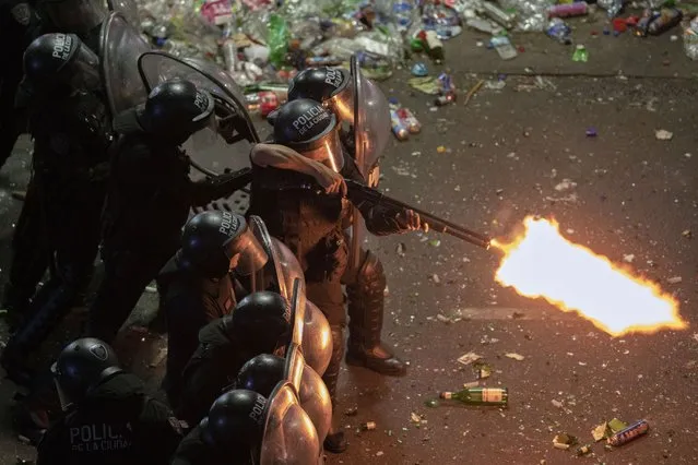 Riot police fires a shotgun as they clear remaining soccer fans who waited for hours for a homecoming parade for the players who won the World Cup at the Obelisk in Buenos Aires, Argentina, Tuesday, December 20, 2022. A parade to celebrate the champions was abruptly cut short Tuesday as millions of people poured onto thoroughfares, highways and overpasses in a chaotic attempt to catch a glimpse of the national team. (Photo by Victor Caivano/AP Photo)