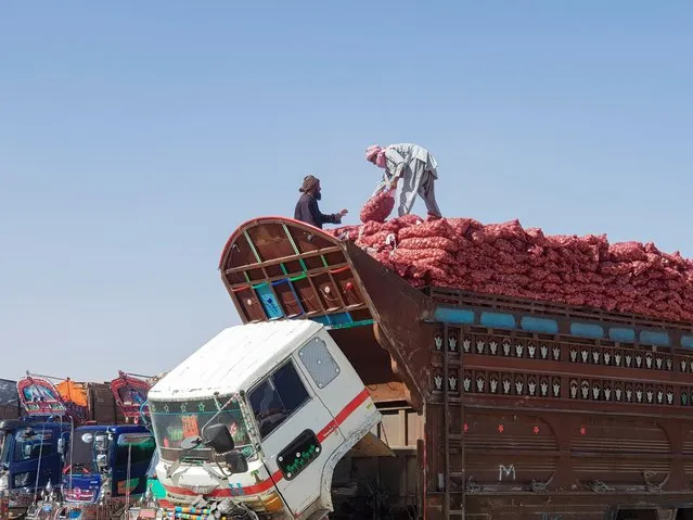 Laborers load sacks of onion from Afghanistan, to supply at a local market, into a truck parked at the Friendship Gate crossing point in the Pakistan-Afghanistan border town of Chaman, Pakistan on September 21, 2021. (Photo by Abdul Khaliq Achakzai/Reuters)