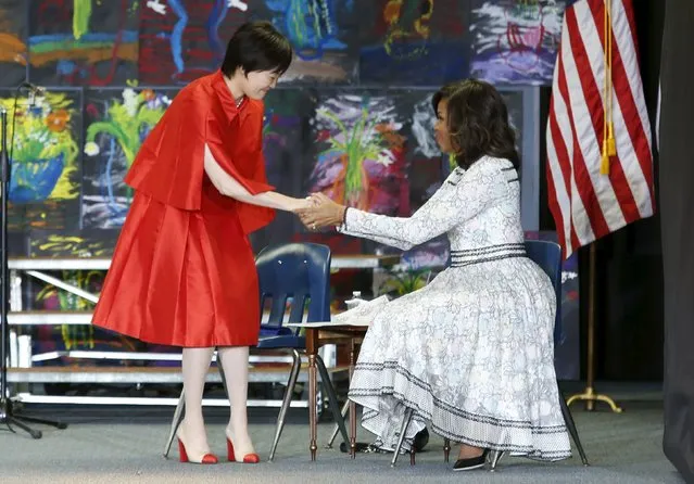 U.S. First Lady Michelle Obama (R) greets Mrs. Akie Abe, wife of Japanese Prime Minister Shinzo Abe, at Great Falls Elementary School in Great Falls, Virginia, April 28, 2015. (Photo by Yuri Gripas/Reuters)